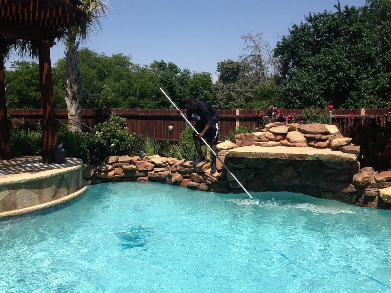 A&M Pool Service employee scrubbing a pool in North Texas